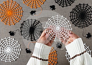 One of beautiful white cotton crocheted side webs in girls hands as a small handmade Halloween gift or autumn home decoration.