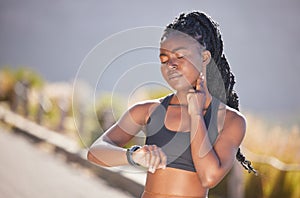 One beautiful young african american woman checking her pulse while exercising outdoors. A fit and sporty female athlete