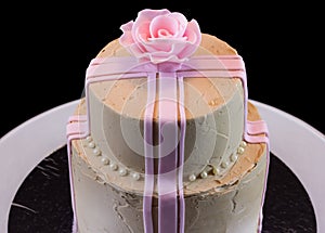 One beige cake with a pink rose