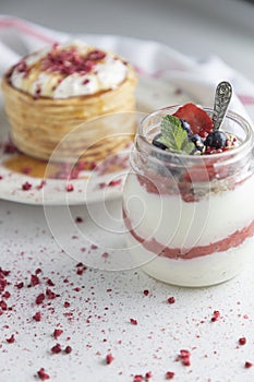 Berry breakfast yogurt pot with a stack of hotcakes photo