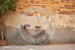 one bicycle parked against a rustic wall