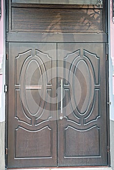 One big closed old brown wooden door on a concrete wall