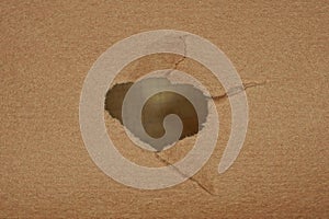 gray hole in a piece of brown paper cardboard