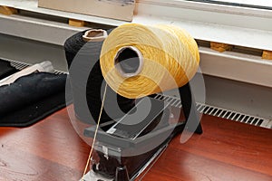 One big yellow bobbin with large mating colored threads in the studio fot interior design workshop on the table with thread