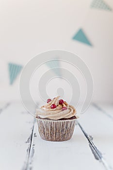 One birthday cupcake with frosting and berries