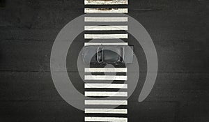 One black car on a zebra pedestrian crosswalk. Black asphalt on a backdrop