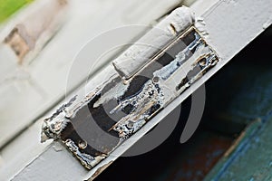 iron door hinge on a white plank of a wooden old door