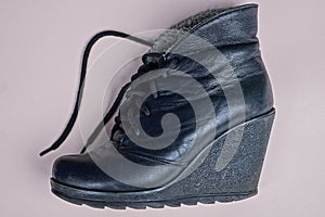 One black leather boot with soles