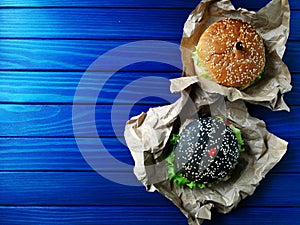 One black and one regular Burger with skewers in form of hearts photo