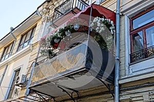 One black open balcony with a row of flowerpots