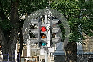 One black retro traffic light on a gray pillar on the street