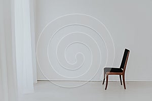 One black vintage chair in an empty white room