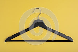 Fashion accessoriesÃÅ½ Black wooden hanger isolated on yellow background
