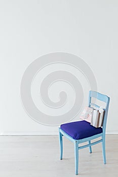 One blue chair with gifts in the interior of a white empty room