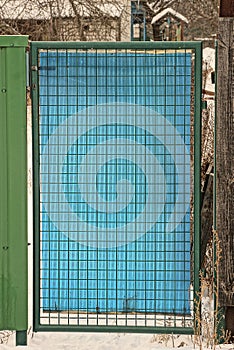 One blue plastic closed door with a green iron grate