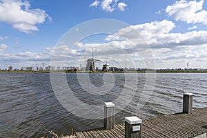One of the boat docks with mooring posts in the lake de Rottemeren with in the background the three windmills Tweemanspolder nr 1,