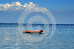 One boat, one seagull and one cloud