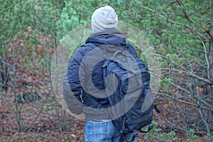 one brack army backpack on the back of a man in a gray hat