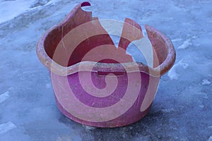 plastic basin stands on the street on white ice
