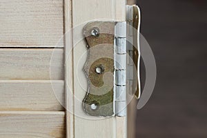 One brown iron door hinge on a gray plank