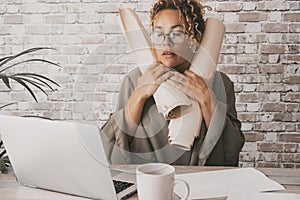 One businesswoman stressed at the desk alone holding design paper documents. Problems during job day in office home workplace.