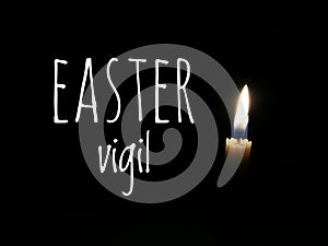 One candle burn brightly on dark background with text written Easter vigil.