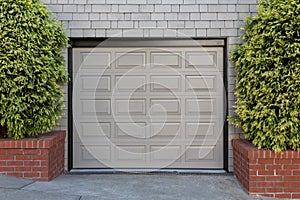 One car garage door between two plants