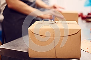 One cardboard box ready to be shipped sitting on metal grey steel table