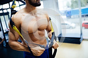 Caucasian man exercising with suspension training trx