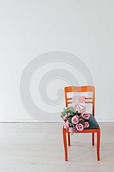 One chair with flowers in the interior of a white empty room