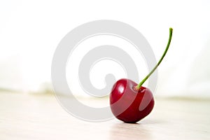 one Cherries Close-up. Cherry on wood and white background. - healthy eating and food concept