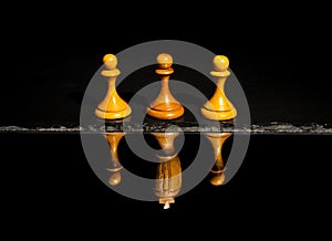 one chess Pawn among the three with a chess King reflection on the water concept of strength and aspirations