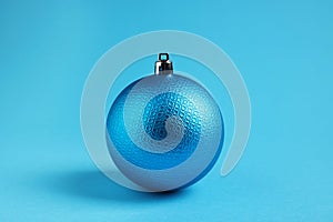 One Christmas ball on light blue background