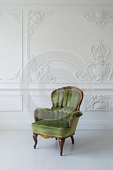 One classic armchair against a white wall and floor. Copy space