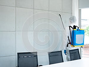 One of a cleaner man use gun spray sanitizer backpack on a meeting wall room for good health stay away from Coronavirus and Anti