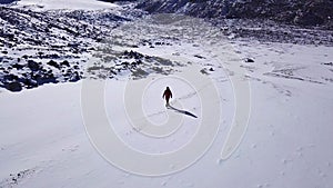 One climber is walking among the snowy mountains.