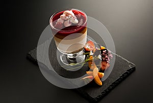 One cocktail in a glass with pieces of fruit on the decorative stone on a dark background