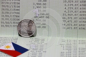 One coin of Philippine peso money on obverse and mini Philippine flag on the book bank. Concept of Saving money