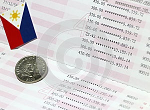 One coin of Philippine peso money on obverse and mini Philippine flag on the book bank. Concept of Saving money