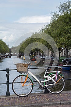 One colourful bike is on the bridge near the canal in Amsterdam