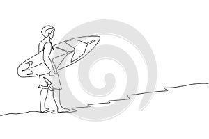 One continuous line drawing of young happy tourist surfer walking on sandy beach and carrying surfboard. Extreme watersport