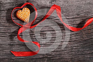 One cookies and heart shaped red ribbon