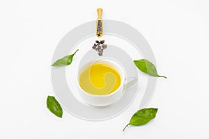 One cup of oolong tea with fresh leaves and a heap of dry green tea on a white background, with copy space for text. Organic