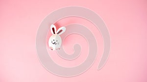 One cute bunny made of white chicken eggs isolated on a light pink pastel background. Happy Easter Day