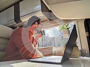 One digital nomad working inside a camper van travel lifestyle vehicle vanlife using laptop computer and roaming internet