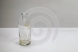 One dirty clear glass medical beaker, aged and patina on a white background
