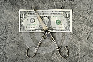 One Dollar banknote is cut with scissors