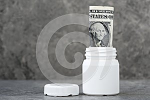 One dollar banknote rolled in the pharmaceutical bottle