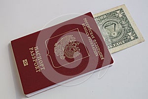 1 one dollar bill lie in red passport of Russian Federation. US dollar banknote inserted in Russian passport  on white photo