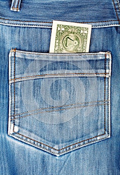 One dollar bill sticking in the back pocket of blue jeans